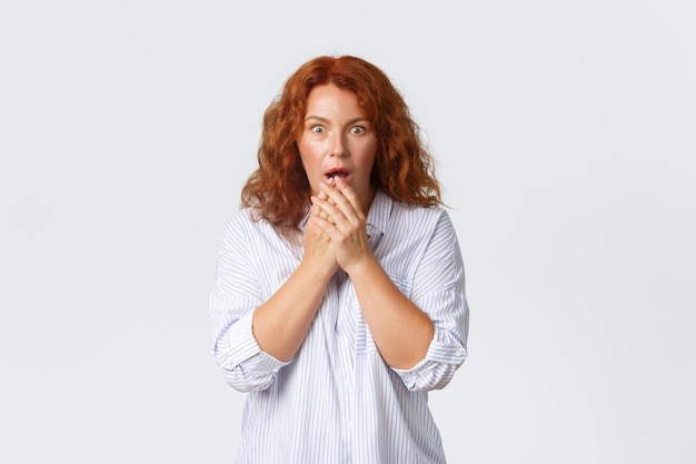 Portrait d'une jeune femme debout sur un fond blanc