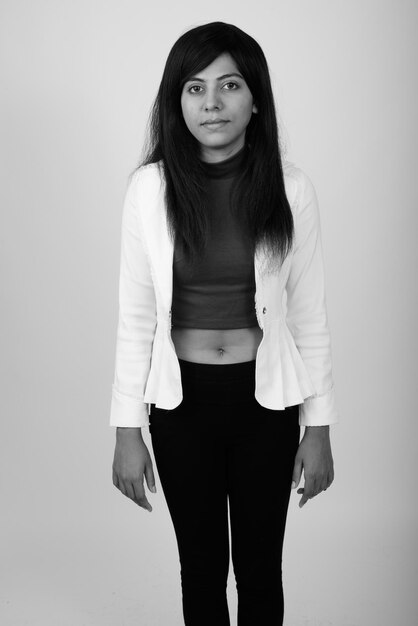 Photo portrait d'une jeune femme debout sur un fond blanc