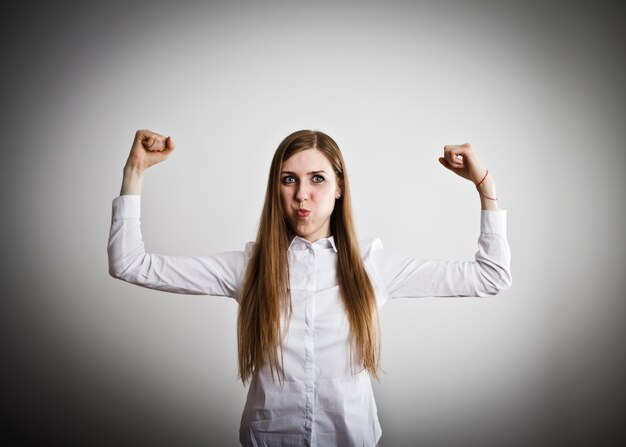 Photo portrait d'une jeune femme debout sur un fond blanc