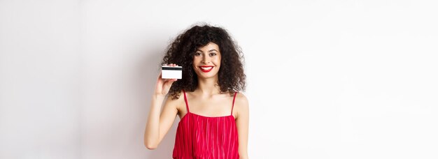 Photo portrait d'une jeune femme debout sur un fond blanc