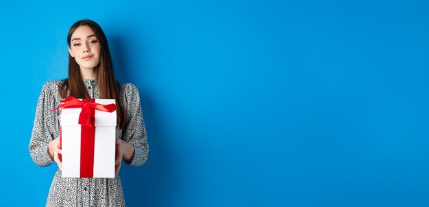 Portrait d'une jeune femme debout sur un fond bleu