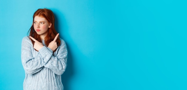 Photo portrait d'une jeune femme debout sur un fond bleu