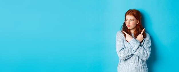 Portrait d'une jeune femme debout sur un fond bleu