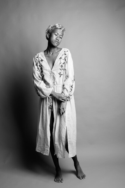 Photo portrait d'une jeune femme debout sur un fond gris