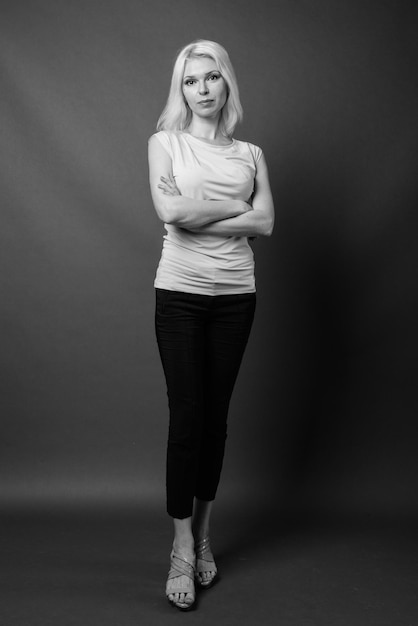 Photo portrait d'une jeune femme debout sur un fond gris