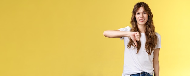 Photo portrait d'une jeune femme debout sur un fond jaune