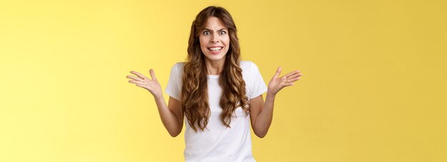 Portrait d'une jeune femme debout sur un fond jaune