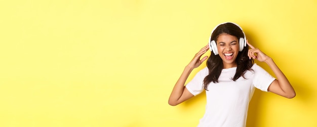 Photo portrait d'une jeune femme debout sur un fond jaune