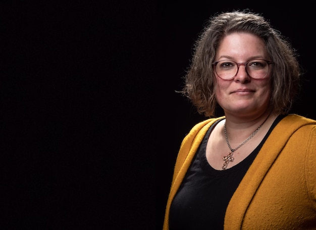 Photo portrait d'une jeune femme debout sur un fond noir