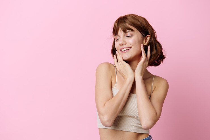 Photo portrait d'une jeune femme debout sur un fond rose