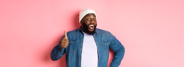 Photo portrait d'une jeune femme debout sur un fond rose