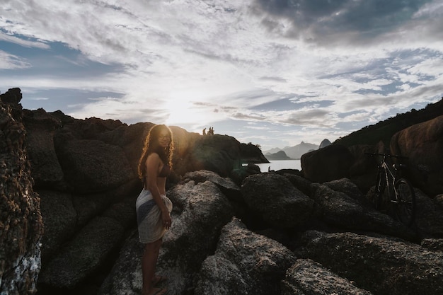 Portrait d'une jeune femme debout sur des formations rocheuses contre le ciel
