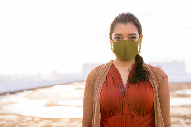 Portrait d'une jeune femme debout sur la plage contre le ciel