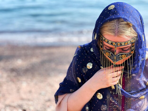 Photo portrait d'une jeune femme debout sur la plage