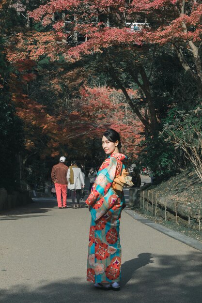 Portrait d'une jeune femme debout sur la route dans le parc.