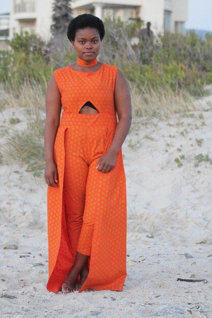 Photo portrait d'une jeune femme debout sur le sable de la plage