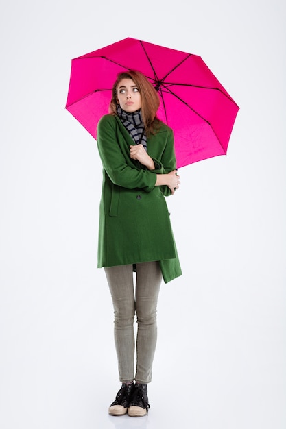 Portrait d'une jeune femme debout sous un parapluie isolé sur fond blanc