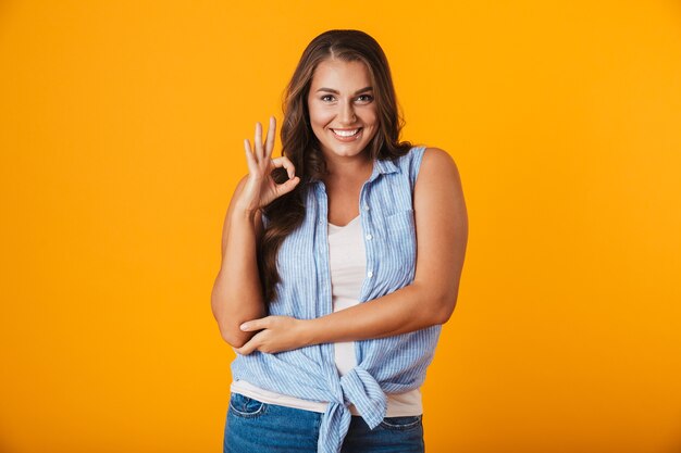 Portrait d'une jeune femme décontractée joyeuse, montrant le geste ok