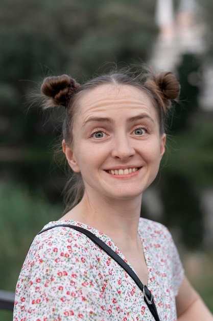 Portrait de jeune femme avec deux queues de cheval souriant joyeusement et levant les sourcils de surprise Cadre vertical