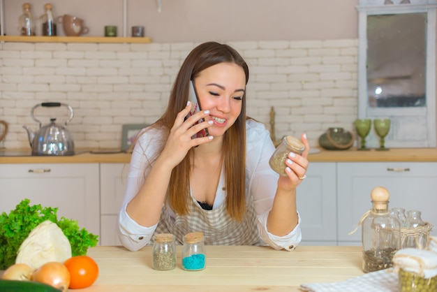 Portrait d'une jeune femme avec différentes épices dans la cuisine