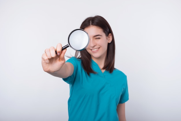 Portrait, de, jeune femme, docteur, regarder, auge loupe, sur, mur blanc