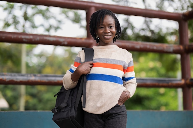 Portrait de jeune femme avec des dreadlocks afro et sac à dos