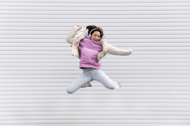 Photo portrait, jeune femme, à, écouteurs, sauter