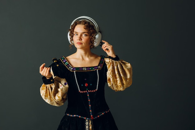 Portrait d'une jeune femme avec des écouteurs sur la tête et vêtue d'une robe vintage écoutant de la musique