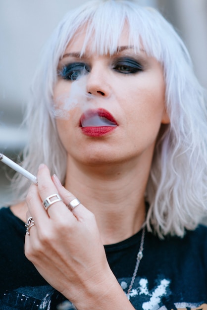 Portrait de jeune femme élégante blonde grunge avec maquillage cigarette