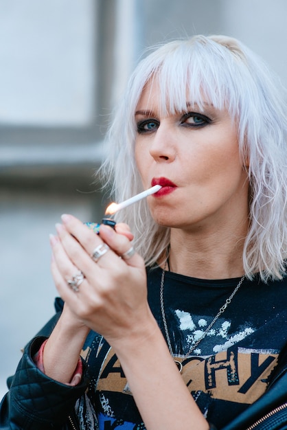 Portrait de jeune femme élégante blonde grunge avec maquillage cigarette