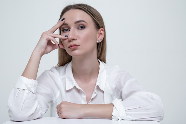 Portrait d'une jeune femme élégante dans une chemise blanche