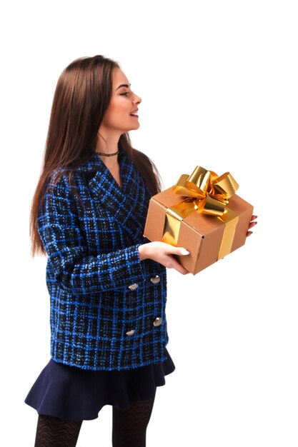 Portrait de jeune femme élégante en manteau bleu présente une boîte-cadeau