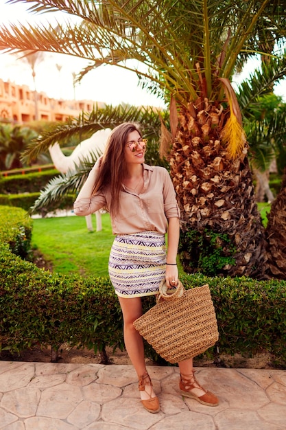 Portrait de jeune femme élégante marchant sous les palmiers tropicaux Vacances d'été Mode
