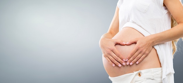 Portrait de la jeune femme enceinte souriante heureuse