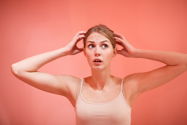 Portrait d'une jeune femme européenne. Elle regarde intensément au loin. Ses yeux et sa bouche sont grands ouverts.