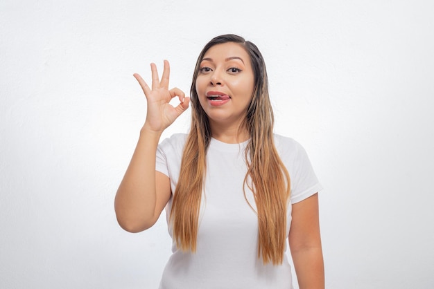 Portrait de jeune femme faisant signe OK avec sa main Jeune femme isolée sur fond blanc faisant signe pouce levé