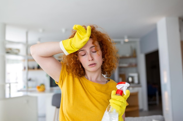 Portrait de jeune femme fatiguée avec des gants en caoutchouc se reposant après avoir nettoyé un appartement Concept d'entretien ménager à domicile