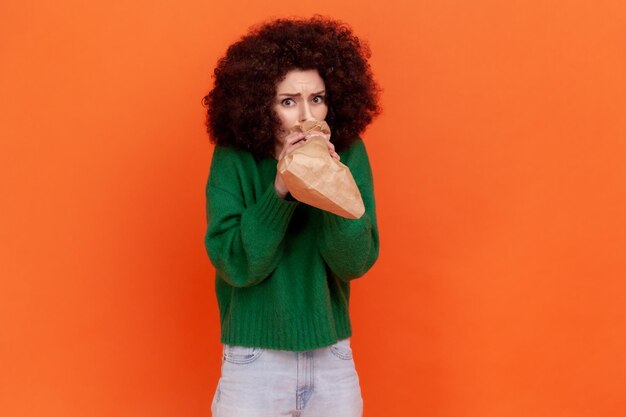 Portrait de jeune femme sur fond orange