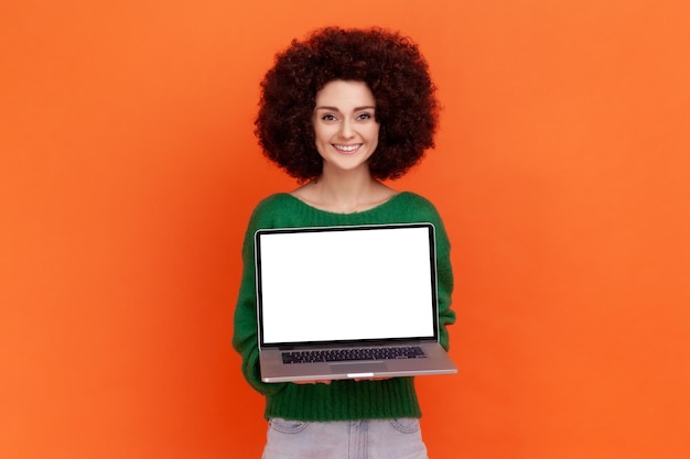 Portrait de jeune femme sur fond orange