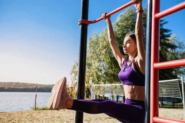 Portrait de jeune femme forte en vêtements de sport accroché au mur