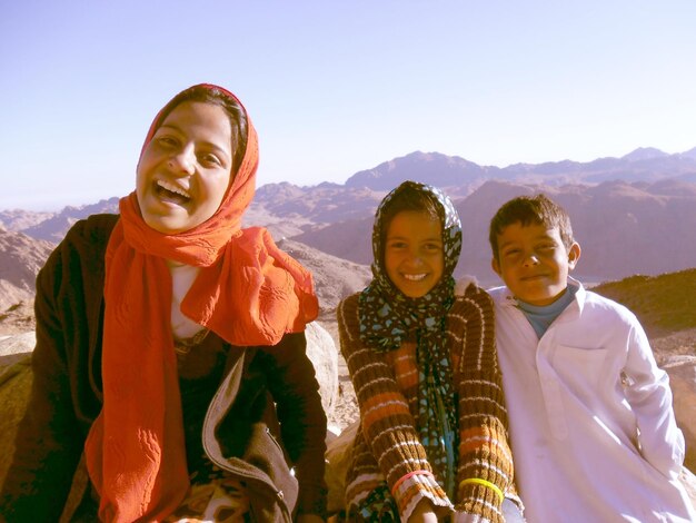 Photo portrait d'une jeune femme heureuse avec des enfants sur la montagne