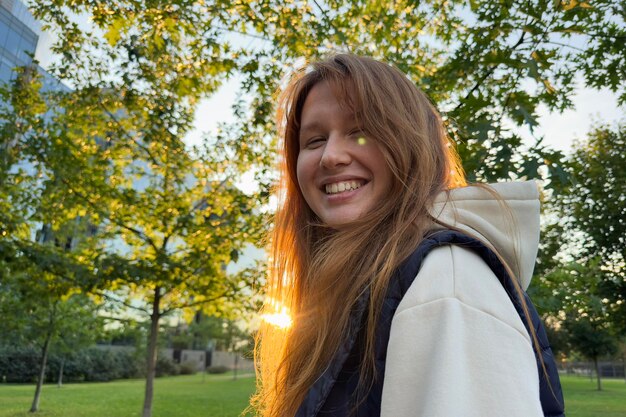 Portrait d'une jeune femme heureuse et joyeuse marchant dehors au parc d'été ou d'automne doré