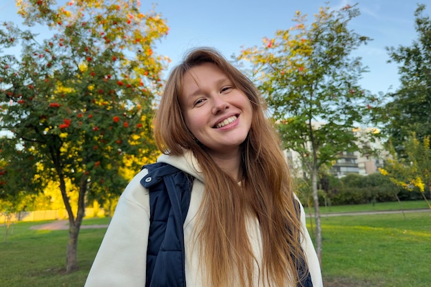 Portrait d'une jeune femme heureuse et joyeuse marchant dehors au parc d'été ou d'automne doré