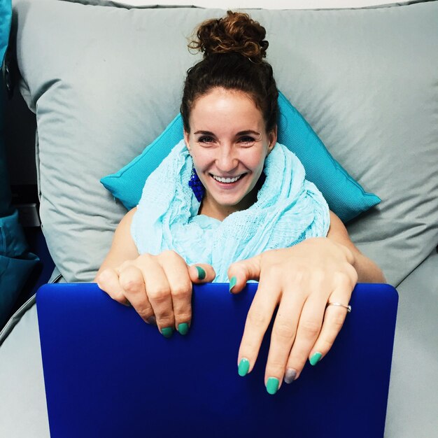 Photo portrait d'une jeune femme heureuse avec un ordinateur portable sur le siège