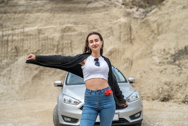 Portrait d'une jeune femme heureuse près d'une voiture