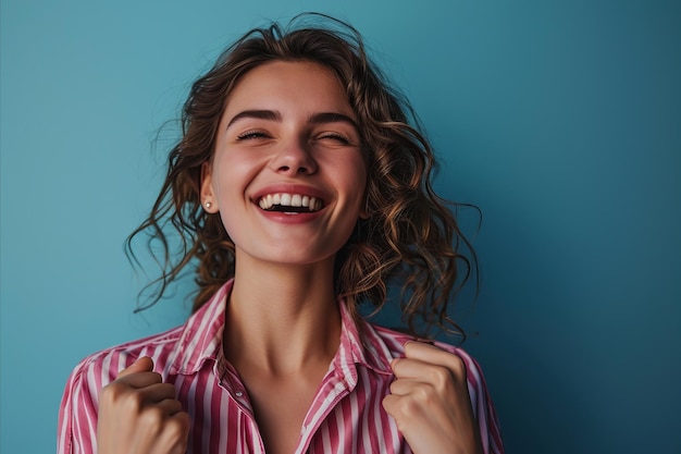 Portrait d'une jeune femme heureuse riant sur un fond bleu photo stock