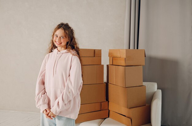 Portrait de jeune femme heureuse se déplaçant avec des boîtes en carton vers un nouvel appartement