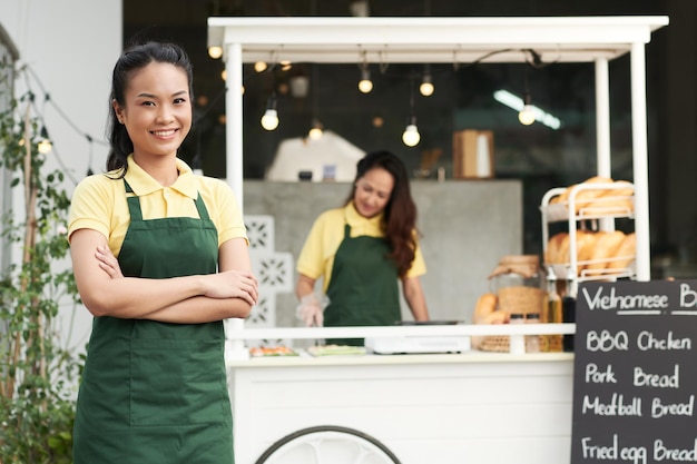 Portrait d'une jeune femme heureuse travaillant comme vendeur d'aliments de rue