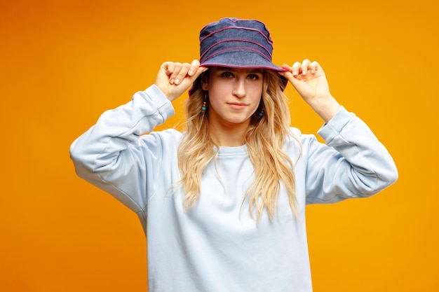 Portrait d'une jeune femme hipster portant un chapeau de Panama sur fond jaune