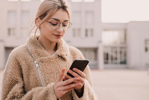 Portrait de jeune femme hipster porter des lunettes et utiliser le téléphone